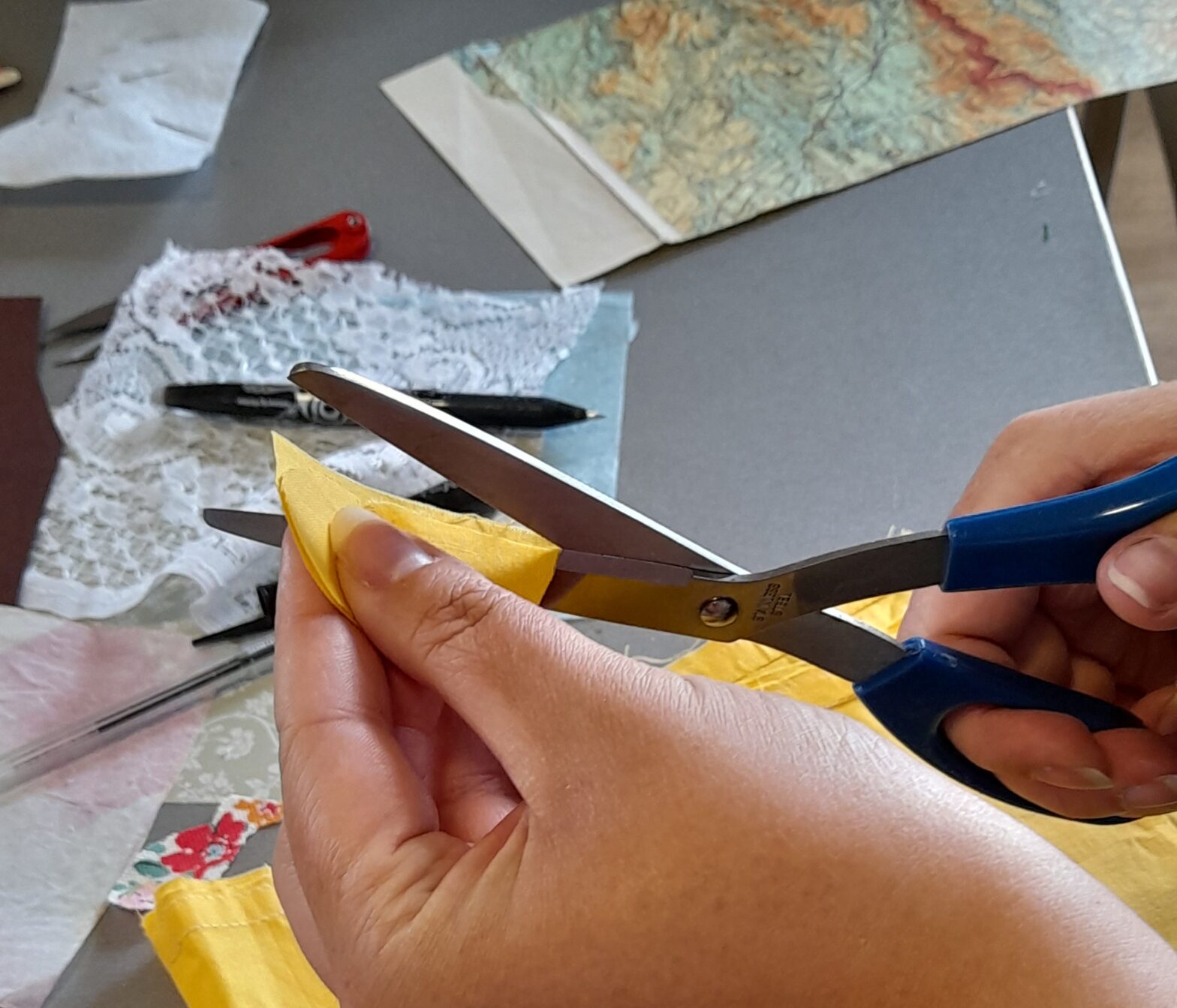 Cutting fabric at an embroidered books workshop